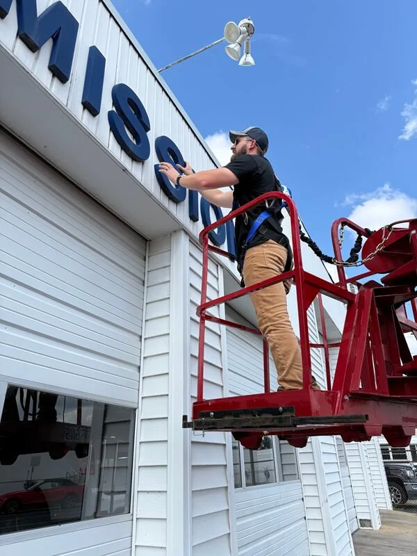 An image of Garrett installing a sign.